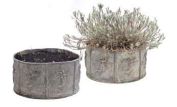 A pair of cylindrical lead planters, each cast with seven panels depicting angels and cupids, 55cm