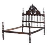 A carved hardwood double bed in 19th century Angli-Indial style, modern, the carved headboard on