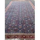 A very large Turkish rug, marked 'J. 1987. G = HEREKE', blue ground with floral design, 620x343