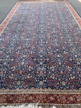 A very large Turkish rug, marked 'J. 1987. G = HEREKE', blue ground with floral design, 620x343