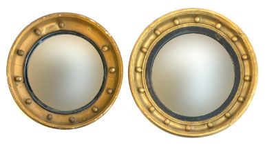 Two Regency circular convex mirrors in cavetto ball moulded frames, one with reeded ebonised slip,