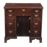A George II mahogany kneehole desk, with frieze drawer above a further central short drawer and