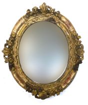 An oval gilt gesso mirror, the frame with floral cresting, 54x47cm overall