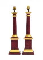 A pair of parcel gilt and simulated marble wooden table lamps, ionic columns on square stepped