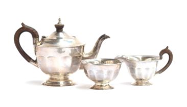 A three piece teaset by Viners, Sheffield 1960, of circular and dodecagonal form, on a spreading