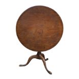 A large 18th century mahogany tripod table, the circular tilt top on a baluster turned column and