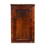 A Biedermeier walnut cabinet, c.1820, the cupboard door with wavy edge, 102cm wide, 49cm deep, 159cm