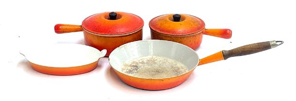 Two Le Creuset style enamel saucepans with lids, 20cm and 22cmD; an enamel frying pan; and a further