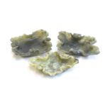 Three Chinese carved spinach green soapstone dishes in the form of lotus leaves, the largest 15.