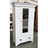 An early 20th century white painted wardrobe with single mirrored door and drawer below,