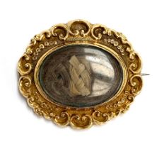 A Victorian gold mourning brooch with woven hair in glazed compartment, unmarked but tests as