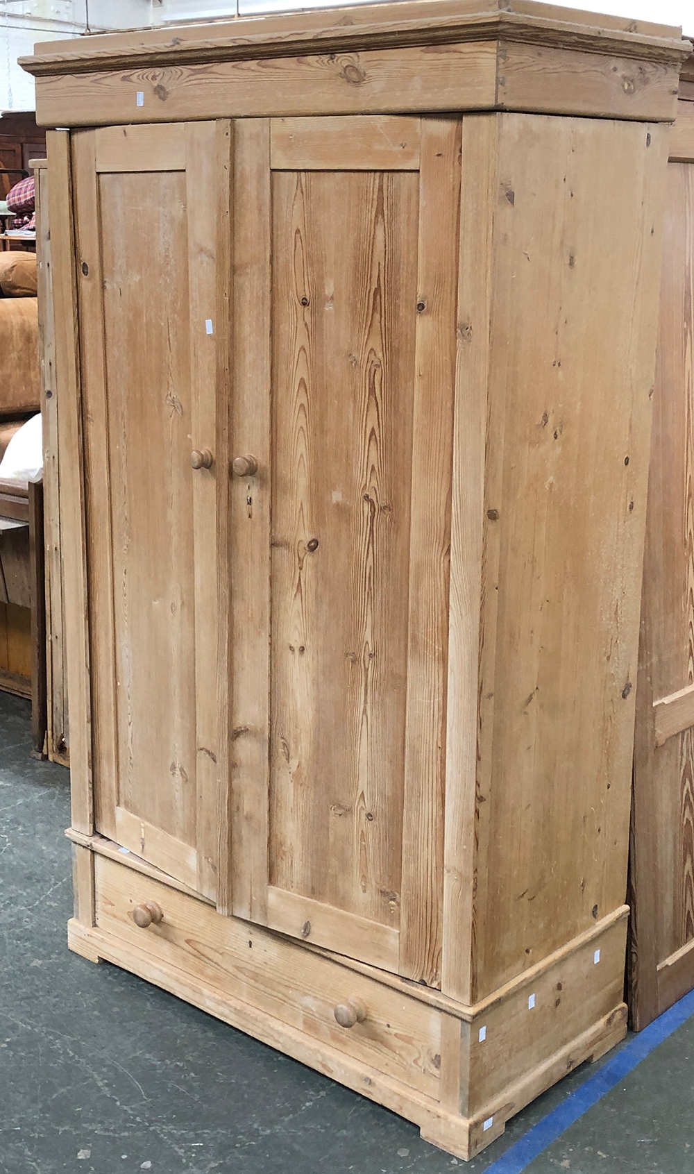 A pine wardrobe, the two panelled doors over a single drawer, 110x53x183cmH (in need of assembly)