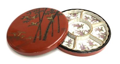 A Japanese hors d'oeuvres tray contained in a red lacquered box decorated with birds and bamboo