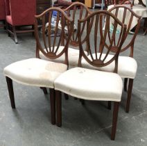 A set of four Regency shield back dining chairs, serpentine stuffover seats, on square tapered legs,