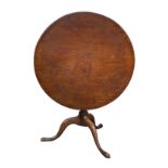 A large 18th century mahogany tripod table, the circular tilt top on a baluster turned column and