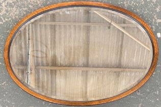 An oval mahogany framed mirror with bevelled glass, 77x51cm