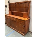 A large 20th century pine kitchen dresser, the base with three drawers over doors, 198x50x187cmH