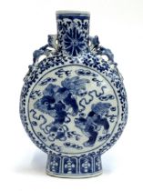 A Chinese blue and white porcelain moon flask, decorated with foo lions amongst ruyi clouds within