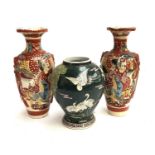 A pair of Japanese vases, 31.5cmH; together with one other depicting storks, with hole drilled for