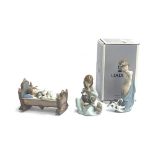 Three Lladro figurines: 'Naughty Puppy', model no. 8106, boxed; together with 'Rock a Bye Baby',