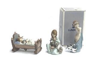Three Lladro figurines: 'Naughty Puppy', model no. 8106, boxed; together with 'Rock a Bye Baby',