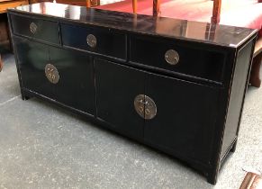 Interior design interest: a black lacquer sideboard of three short over four cupboard doors,
