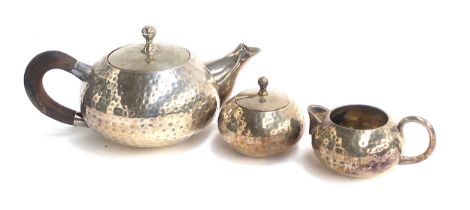 An Arts & Crafts style three piece plated teaset with planished finish