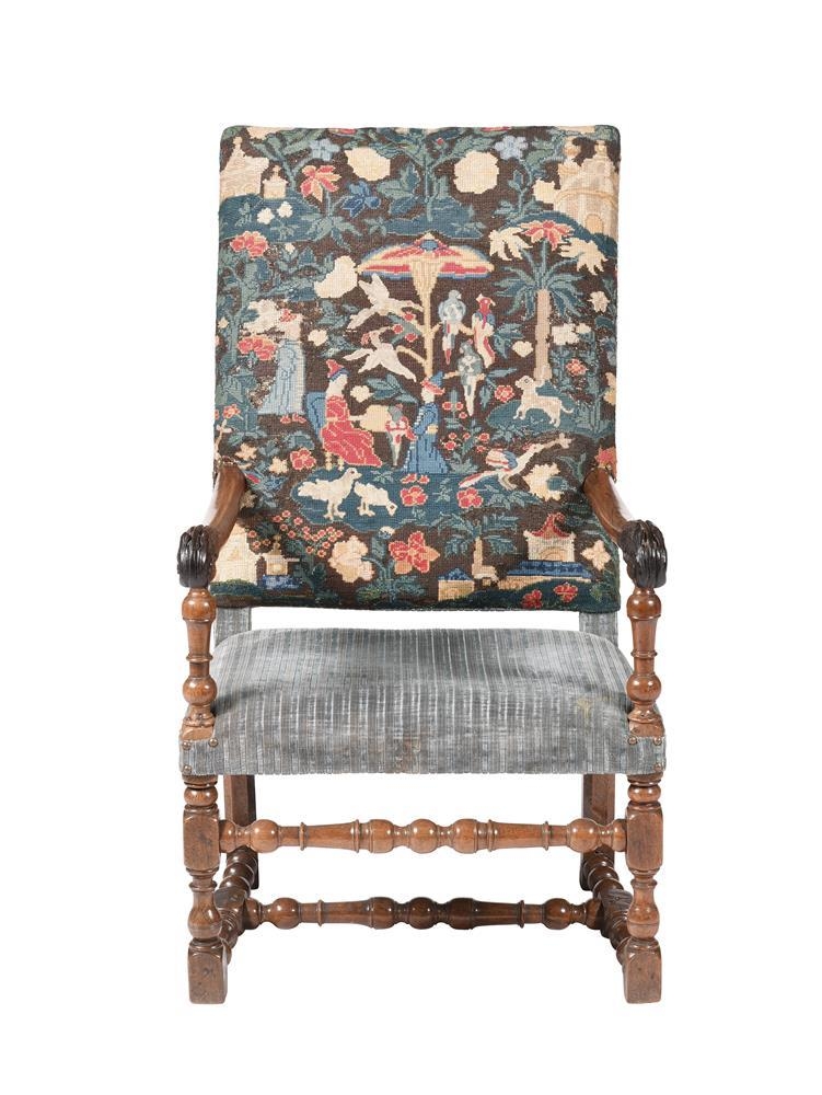 An early 18th century Continental walnut high back armchair, the back upholstered with needlework