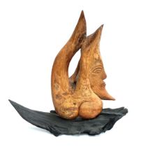 An abstract carved wooden sculpture of a crescent moon, on a naturalistic base, 61cmH