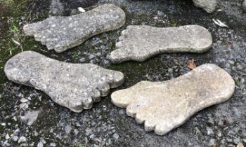 A set of four composite stone slabs in the form of feet, each approx 57cmW