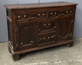 An 18th century and later century oak kitchen dresser, the top with four shelves with pigeon holes