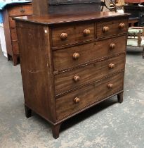 A late George III mahogany chest of two short over three graduating drawers, with turned wooden