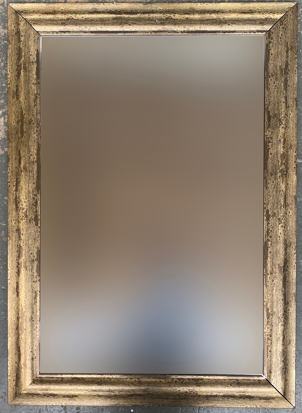 A contemporary wall mirror with bevelled glass and distressed gilt style frame, 108x77cm