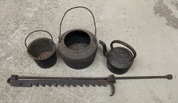 Two cast irons pots, together with a cast iron fireside pot hanger