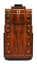 A French Art Deco maccasar ebony pedestal chest, stepped top, over a pair of cupboard doors and an