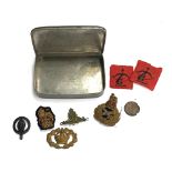 A tin containing military regimental badges, 'Malborough College Corps', Royal Navy artillery