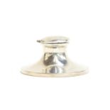 A George V silver capstan inkwell, the base 10.7cm diameter, with mismatched glass liner, Chester