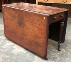 A 19th century mahogany rectangular drop leaf table, on turned tapering legs and casters,