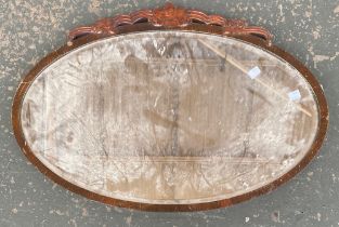 An oval mirror with bevelled glass, 71x47cm