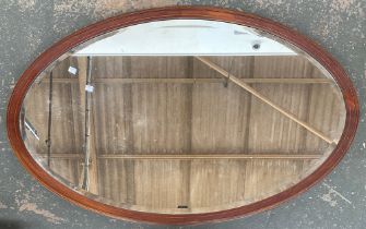 A large early 20th century oval mahogany and line inlaid mirror with bevelled glass, 122x76cm