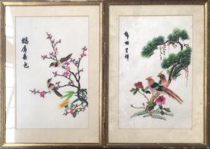 A pair of 20th century Chinese embroideries on silk, each depicting a pair of birds on branches,