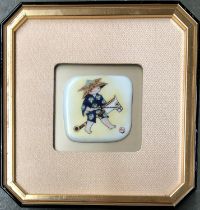A painted Japanese porcelain plaque depicting a child riding a hobby-horse, wearing an origami