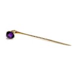 A yellow metal stickpin set with an amethyst, tests as 14ct or higher, 1.4g gross weight