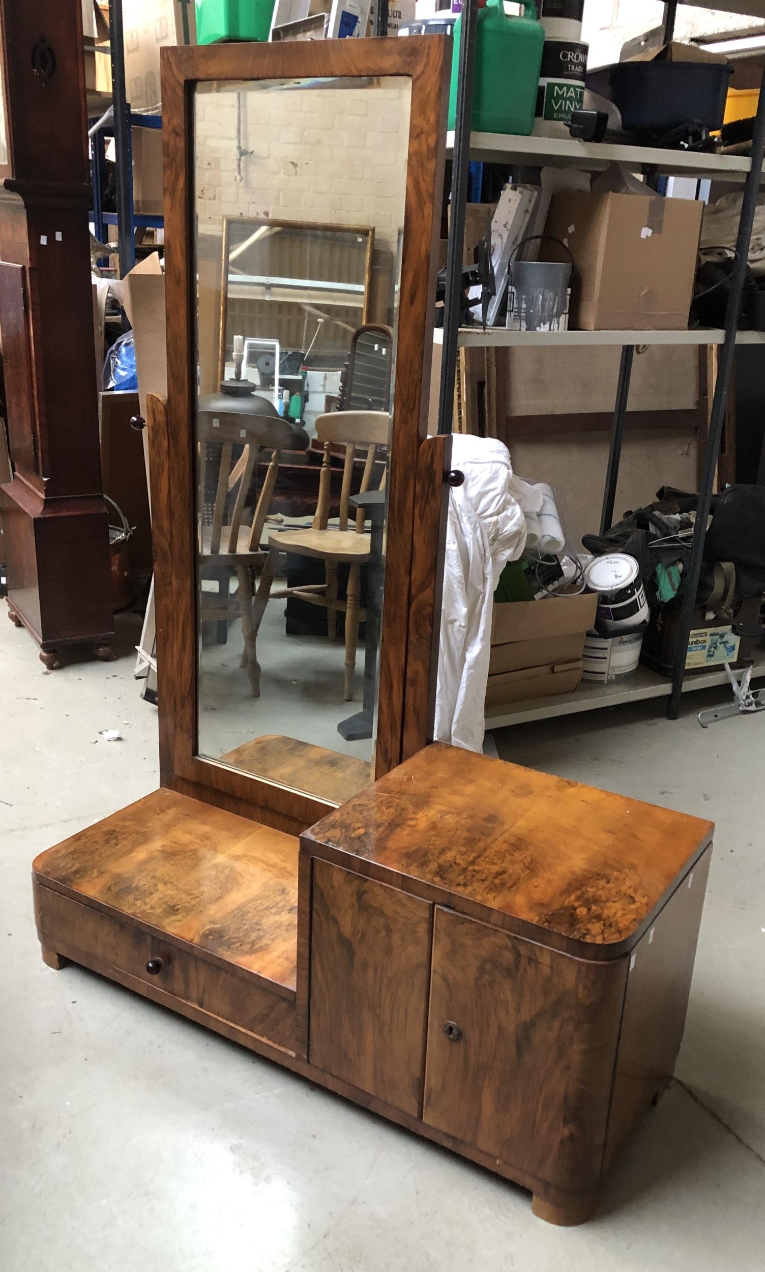 An Art Deco burr walnut veneer asymmetrical dressing mirror, with stepped low cupboard and drawer,