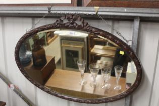 A bevel edged oval wall mirror