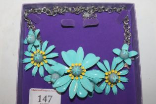 A boxed Daisy necklace
