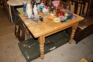 A stripped pine kitchen table raised on turned sup