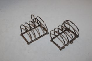 A pair of silver four slice toast racks raised on