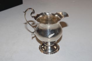 A silver cream jug on flared pedestal base with wavy rim decoration, Hallmarked London 1919, maker