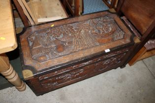 A brass mounted carved camphor wood trunk